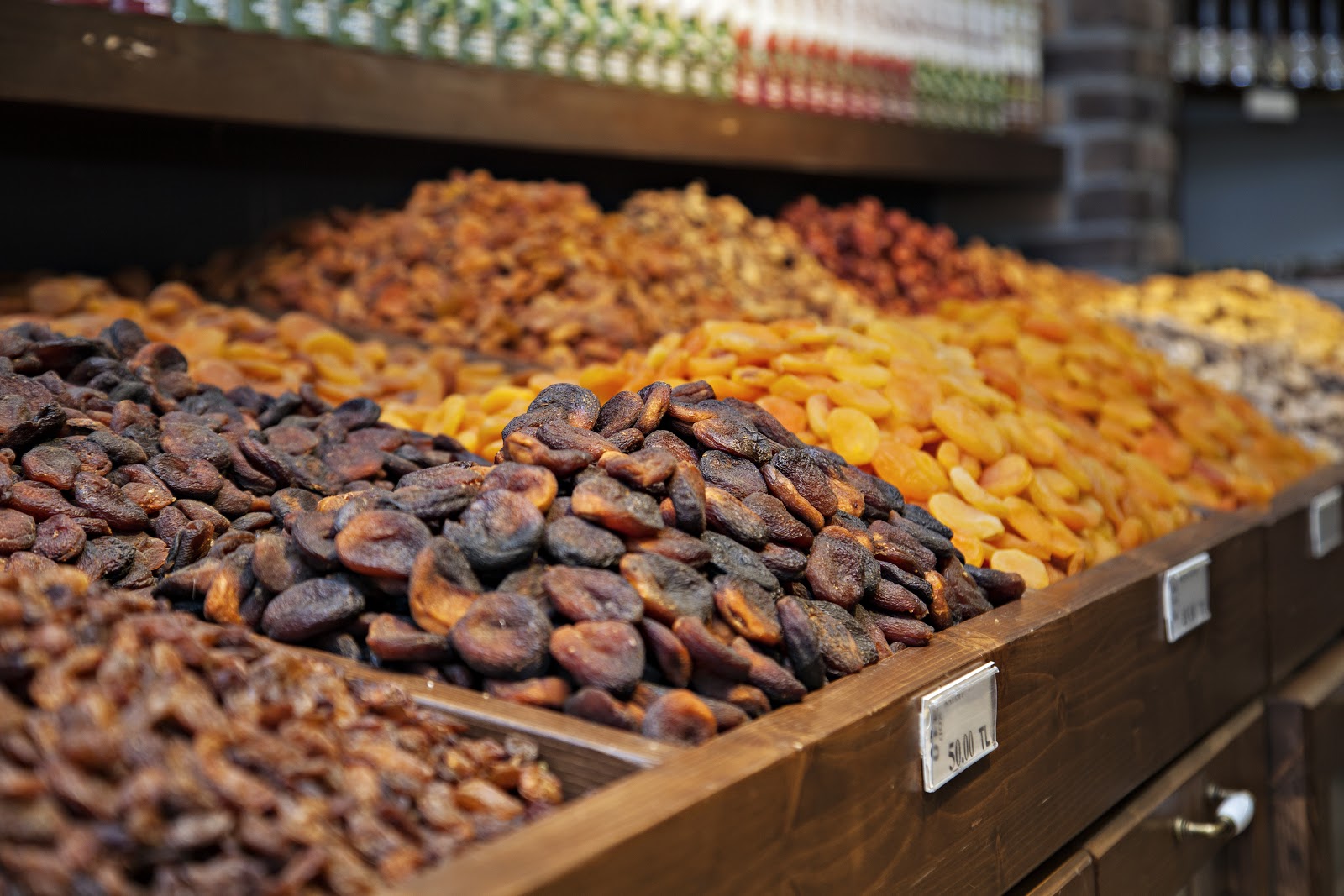 A market stall piled high with varieties of dried fruit including prunes and apricots.